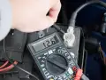 Sprawdzanie, jak sprawdzić czy akumulator jest dobry, za pomocą multimetru pokazującego 12.6V.