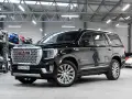 Czarny GMC Yukon Denali lśni w salonie samochodowym, gotowy na przygodę.