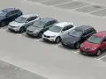 Rząd siedmiu SUV-ów zaparkowanych na placu.