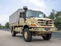 Beżowy Mercedes Zetros 2036 A 4x4 z plandeką jedzie po drodze, gotowy na każde wyzwanie.
