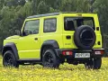 Jaskrawożółty Suzuki Jimny na tle łąki z żółtymi kwiatami. Sprawdź aktualną suzuki jimny cena i wybierz się na przygodę!