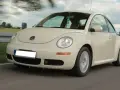 Jasny Volkswagen Beetle w ruchu na drodze, z rozmytym tłem.