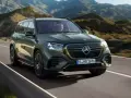 Zielony Mercedes GLS 580 pędzi po krętej drodze wśród gór.