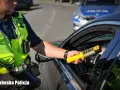 Policjant z Lubuskiej Policji bada kierowcę alkomatem. Za jazdę po alkoholu, nawet 1 promil, prawo jazdy jest zabierane.