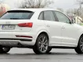 Biały SUV Audi Q3, idealny suv do 70 tys. zł, z polskimi tablicami rejestracyjnymi PO 7H495, widoczny z tyłu i z boku.