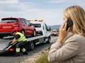 Pomoc drogowa na 1500 km. Kierowca zabezpiecza auto na lawecie, a kobieta wzywa pomoc przez telefon.