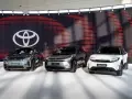 Trzy nowoczesne japońskie marki samochodów: Toyota C-HR+, bZ4X i Urban Cruiser, prezentowane na tle logo Toyoty.
