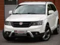 Biały Fiat 4x4 z czarną atrapą chłodnicy i chromowanymi elementami. Auto stoi na kostce brukowej przed budynkiem z cegły.