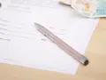 Długopis na dokumencie z polami do podpisu i daty. Obok leżą banknoty. To może być beesafe wypowiedzenie oc.