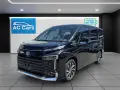 Czarny minivan Toyota Voxy stoi w salonie samochodowym AC Cars.