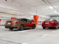 Brązowa Toyota Camry i czerwona Skoda Superb stoją w garażu podziemnym.