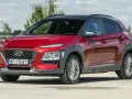 Czerwony, mały SUV Hyundai Kona z czarnym dachem, zaparkowany na zewnątrz.
