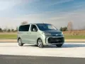 Nowy, zielony minivan Toyota Proace na tle nieba i pól. Idealny na rodzinne wycieczki.