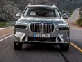 Szary BMW X7M pędzi krętą drogą przez pustynny krajobraz.