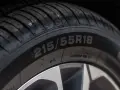 Zbliżenie na bieżnik opony z widocznym oznaczeniem 215/55R18.
