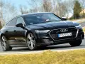 Czarny Audi A7 na drodze. Sprawdź aktualną audi a7 cena i możliwości tego sportowego sedana.