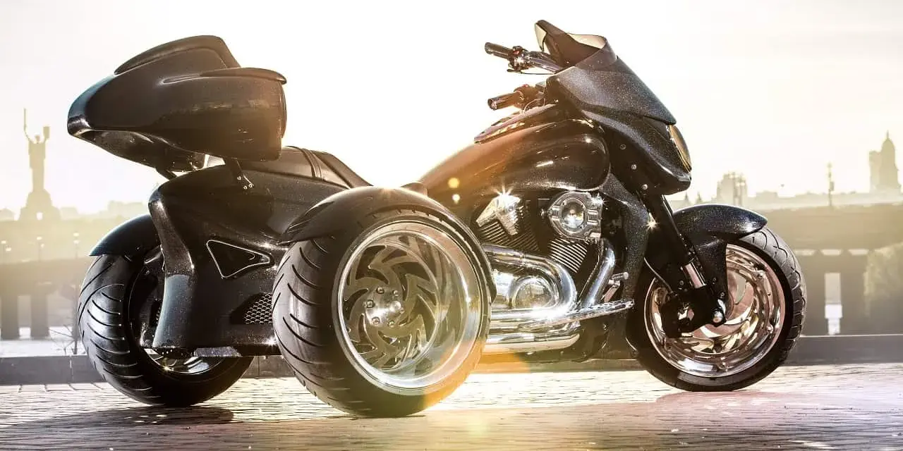 Stylowe motocykle trójkołowe na kat B. Błyszczące, czarne, z chromowanymi felgami, gotowe na podbój miasta.