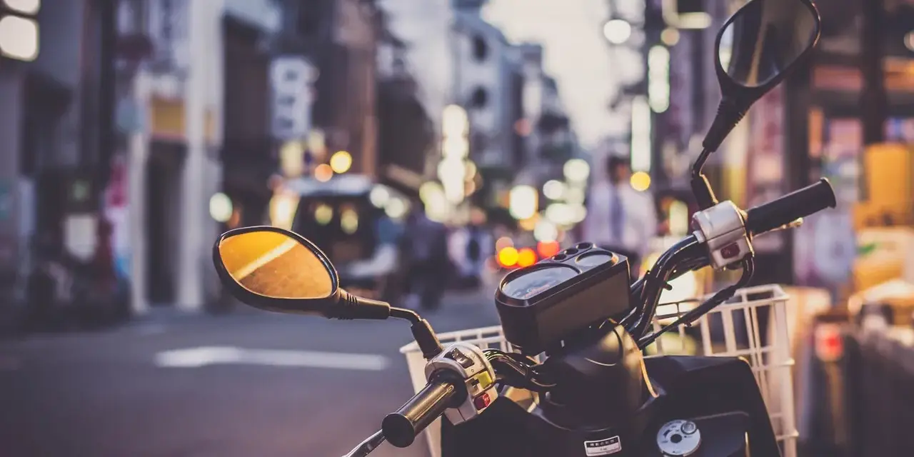 Kierownica skutera 125 z koszykiem, gotowa na miejską przygodę. Pomyśl o ubezpieczeniu motocykla 125, by podróżować bezpiecznie.