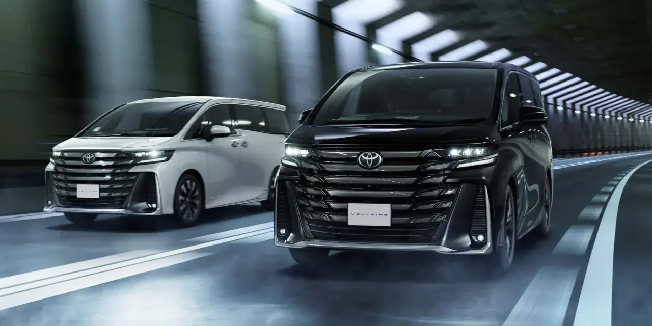 Dwa luksusowe minivany Toyota Vellfire jadące w tunelu.