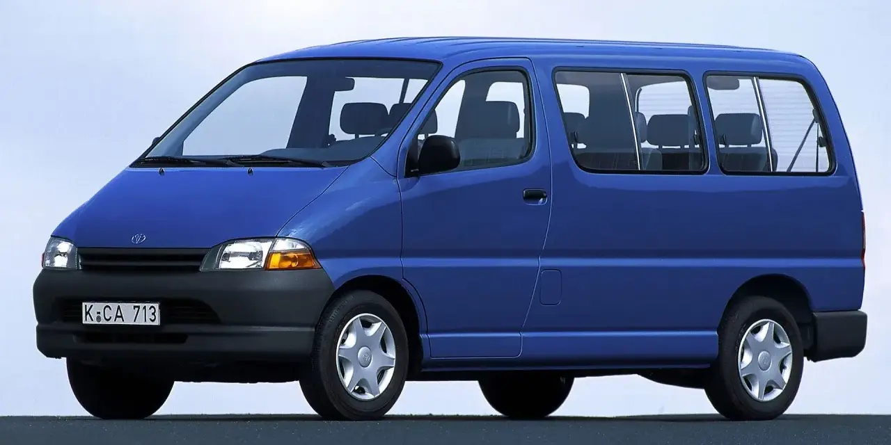 Niebieski van Toyota Hiace z lat 90. z widocznymi siedzeniami i oknami.