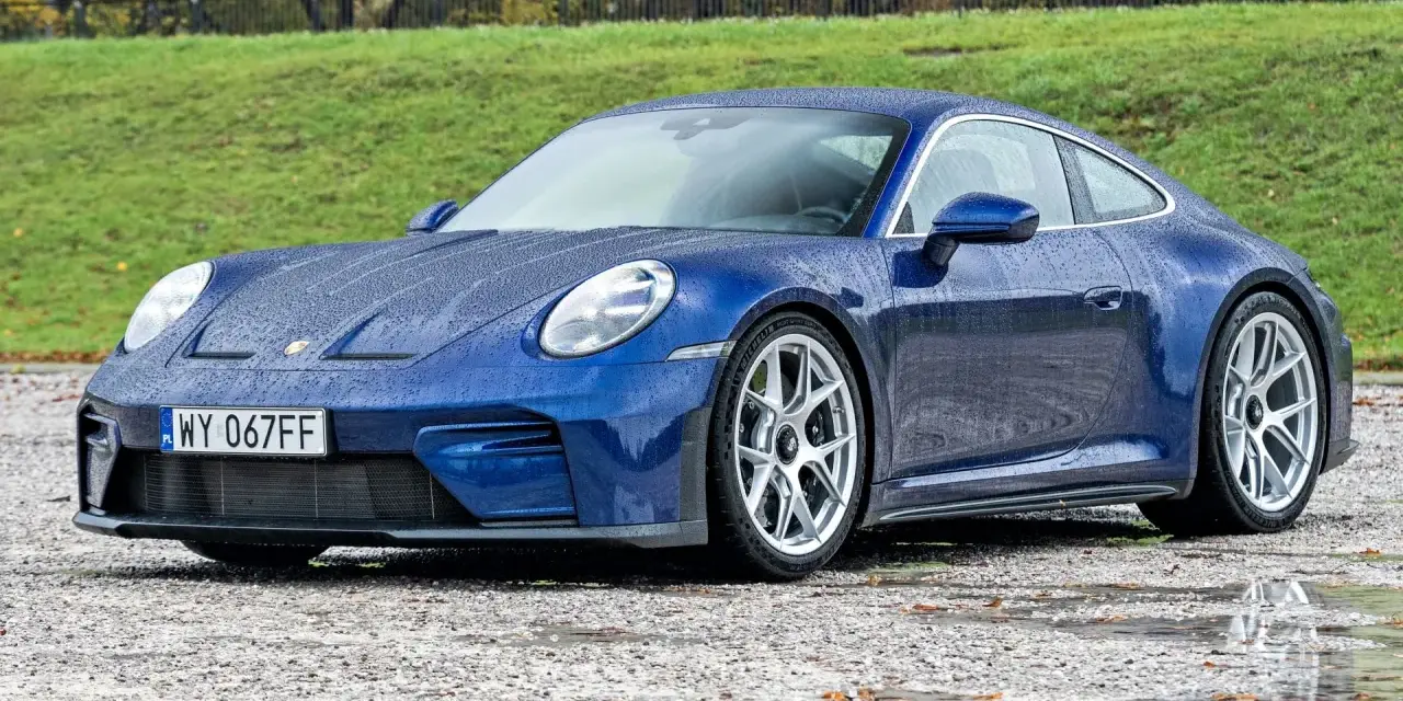 Niebieskie Porsche 911 na mokrej nawierzchni. Zastanawiasz się nad porsche 911 cena? Ten model zachwyca.