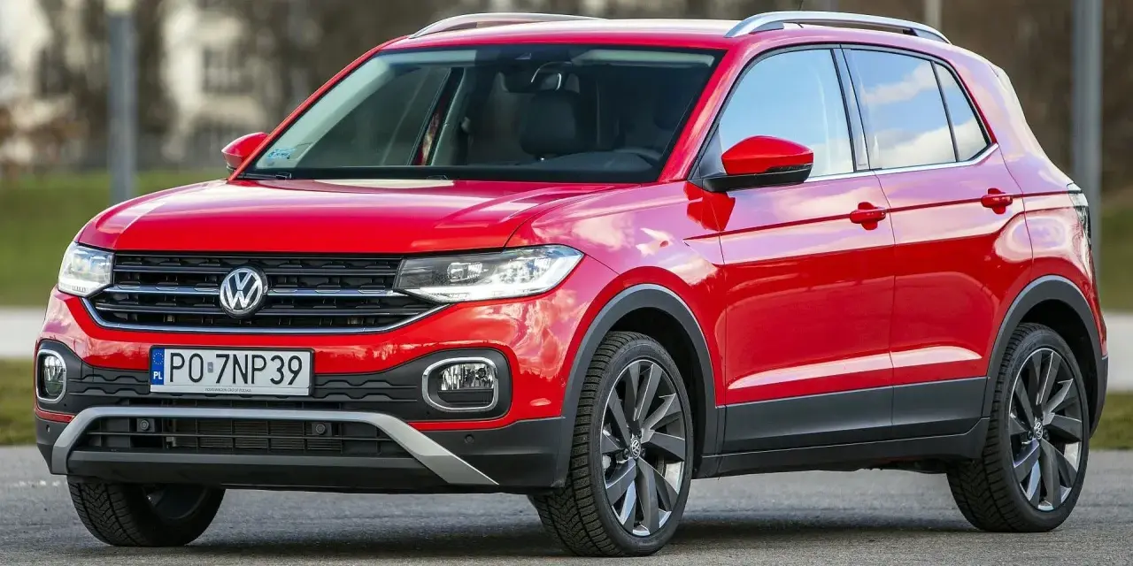 Czerwony, używany Volkswagen T-Cross z polskimi tablicami rejestracyjnymi PO 7NP39 stoi na drodze.