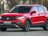 Czerwony, używany Volkswagen T-Cross z polskimi tablicami rejestracyjnymi PO 7NP39 stoi na drodze.