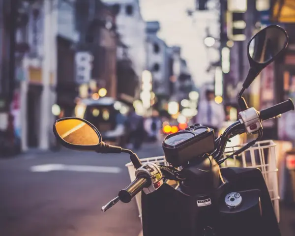 Kierownica skutera 125 z koszykiem, gotowa na miejską przygodę. Pomyśl o ubezpieczeniu motocykla 125, by podróżować bezpiecznie.