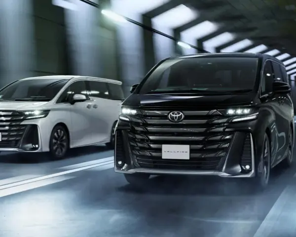 Dwa luksusowe minivany Toyota Vellfire jadące w tunelu.