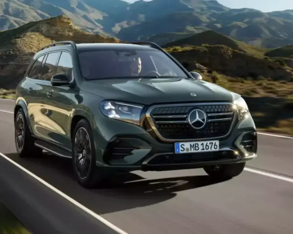 Zielony Mercedes GLS 580 pędzi po krętej drodze wśród gór.