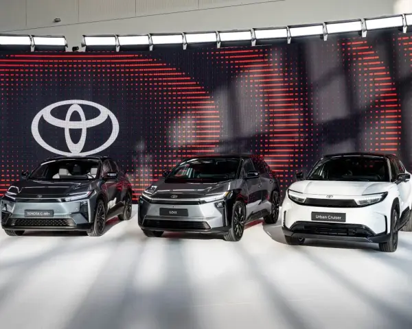 Trzy nowoczesne japońskie marki samochodów: Toyota C-HR+, bZ4X i Urban Cruiser, prezentowane na tle logo Toyoty.