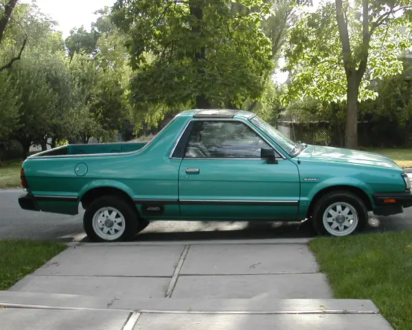 Zielony Subaru Brat z lat 80. stoi na podjeździe, gotowy na przygodę.