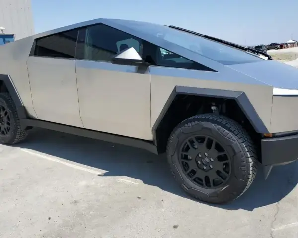 Futurystyczny Tesla Cybertruck na betonowym placu. Zastanawiasz się nad jego tesla cybertruck cena?