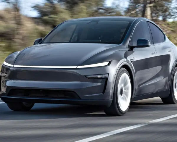 Szary Tesla Model Y w ruchu. Sprawdź aktualną tesla model y cena i możliwości tego elektrycznego SUV-a.
