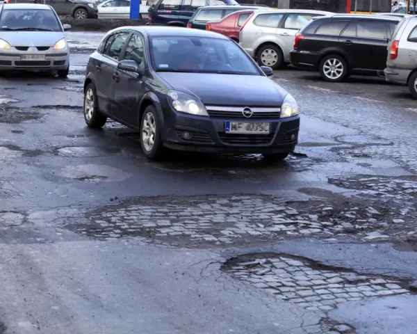 Samochody jadą po dziurawej drodze. Czy warto wykupić ubezpieczenie Europa Ubezpieczenia opinie?