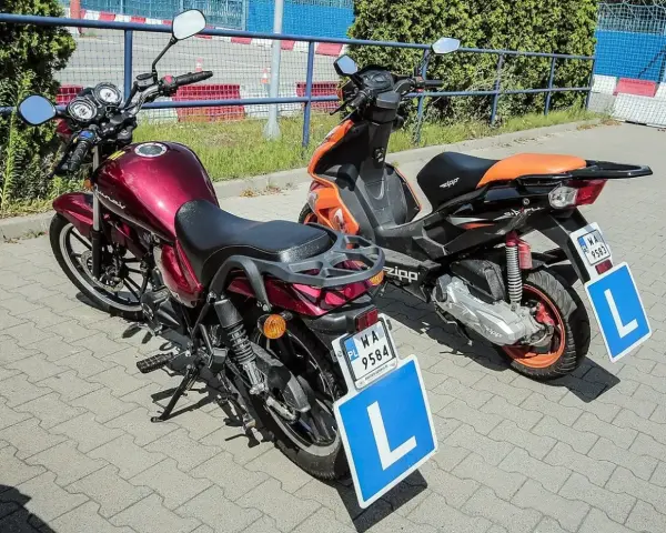 Dwa pojazdy, motocykl i skuter, z tabliczkami "L" na błotnikach, gotowe do nauki jazdy. Karta motorowerowa wkrótce będzie ich przepustką.
