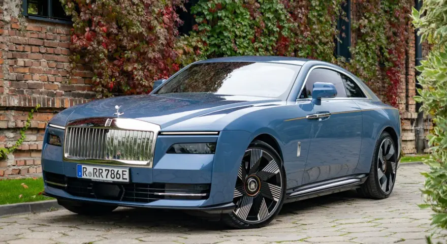 Niebieski Rolls-Royce Ghost na bruku. Zastanawiasz się nad rolls royce cena? Ten luksusowy samochód to marzenie wielu.