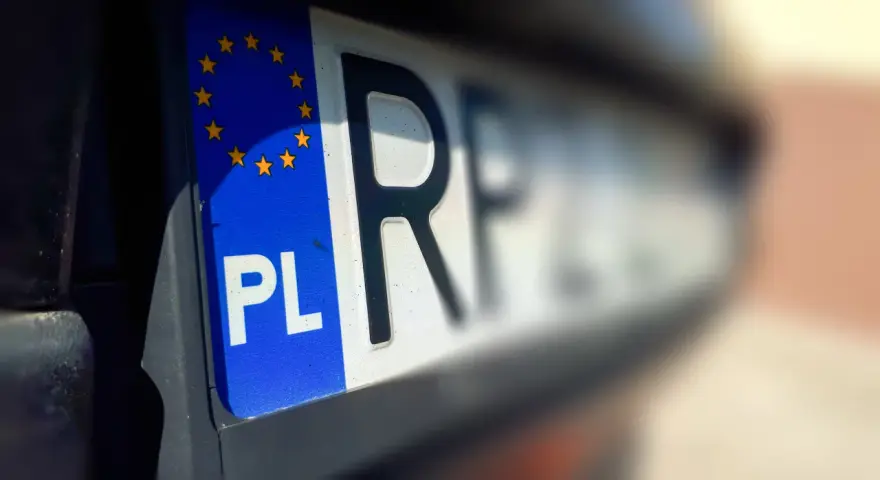 Zbliżenie na polską tablicę rejestracyjną z symbolem UE. Zastanawiasz się, ile czasu na wyrejestrowanie auta?