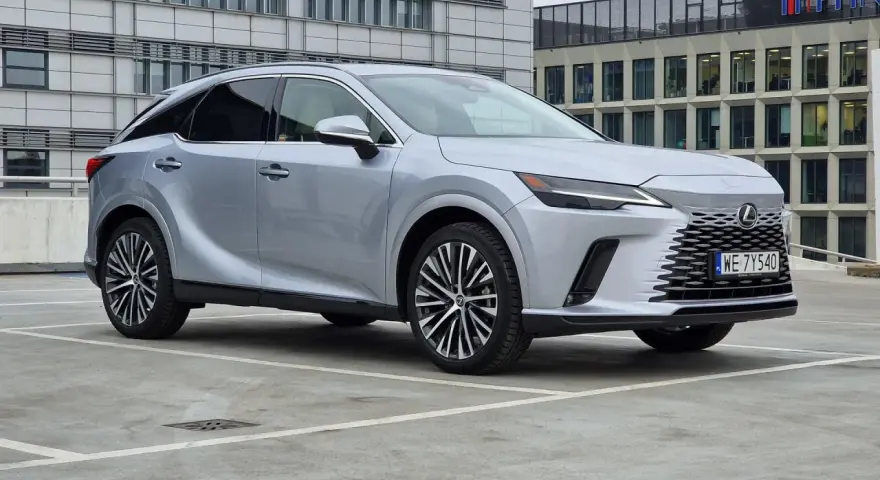 Eleganckie japońskie auta, jak ten srebrny Lexus, prezentują się nowocześnie na tle biurowców.