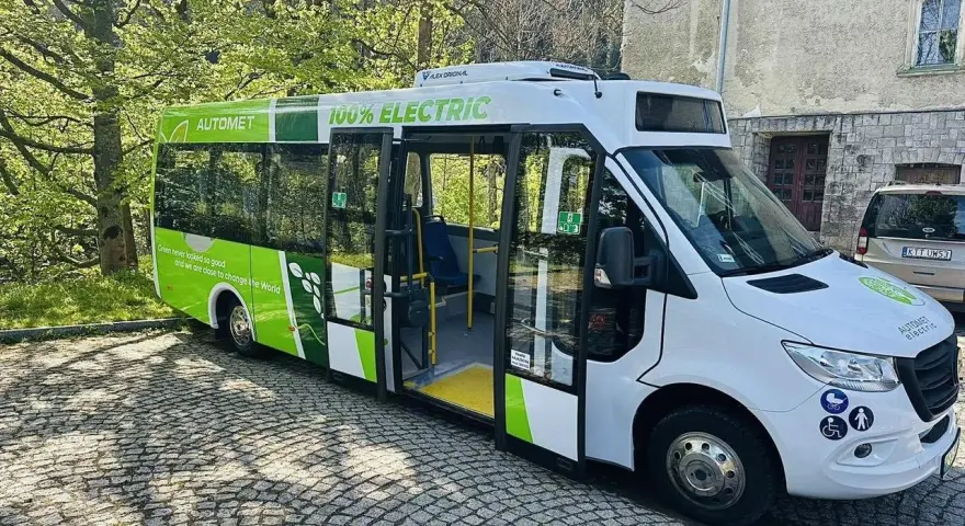 Zielony, elektryczny Automet gotowy do zabrania turystów na Morskie Oko. Ekologiczny transport w malowniczym otoczeniu.