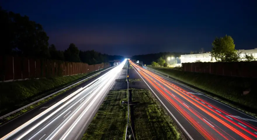 Nocne smugi świateł samochodów na autostradzie A4 między Katowicami a Krakowem. Opłaty za przejazd nie zatrzymują ruchu.