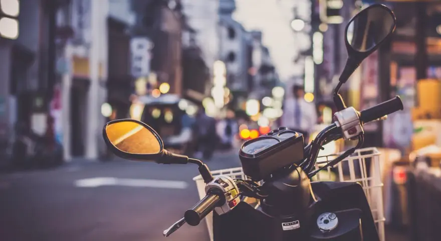 Kierownica skutera 125 z koszykiem, gotowa na miejską przygodę. Pomyśl o ubezpieczeniu motocykla 125, by podróżować bezpiecznie.