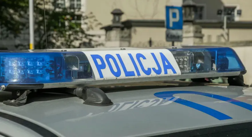 Niebieskie światła policyjne i napis "POLICJA" na dachu radiowozu. Uważaj na przegląd, bo czeka mandat za brak przeglądu.
