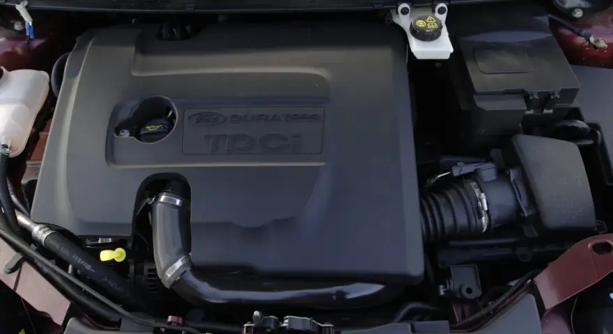 Silnik Ford Focus MK2 1.6 TDCI. Widoczna czarna osłona silnika z napisem "DURATORQ TDCI".