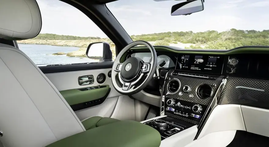 Wnętrze luksusowego Rolls-Royce SUV z zielonymi i białymi skórzanymi detalami, widok na morze.