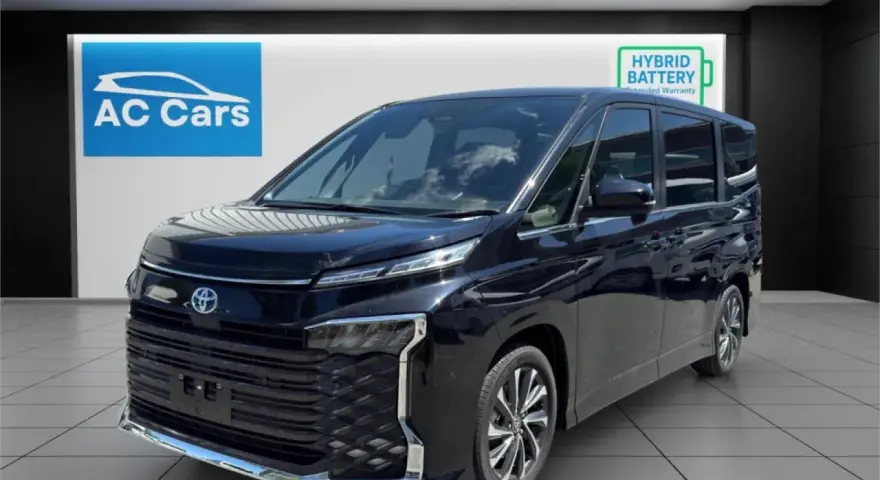 Czarny minivan Toyota Voxy stoi w salonie samochodowym AC Cars.