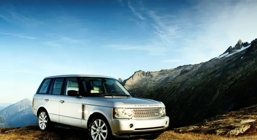 Srebrny Range Rover Vogue na tle górskich szczytów. Gotowy na każdą przygodę.