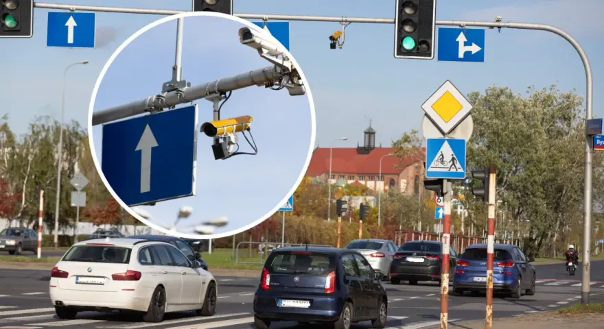 Widok na skrzyżowanie z sygnalizacją świetlną i znakami drogowymi. W powiększeniu widać kamery rejestrujące przejazd na czerwonym świetle.