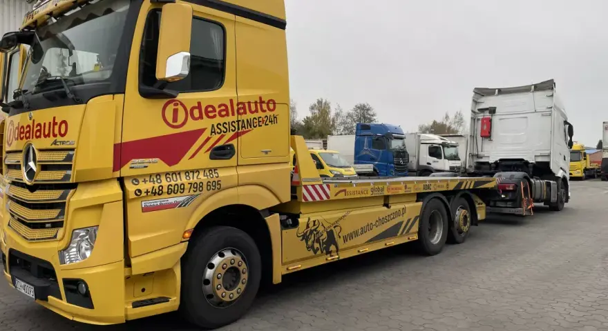 Żółta laweta "Idealauto" z numerami kontaktowymi. Zastanawiasz się, ile kosztuje laweta? Sprawdź ofertę tej firmy!