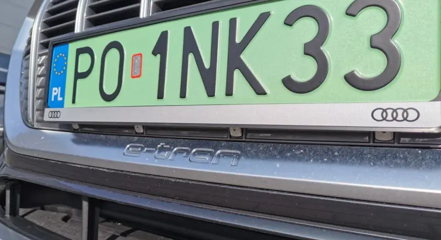 Zielone tablice rejestracyjne z numerem PO 1NK33 na samochodzie Audi e-tron.